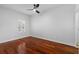 This bedroom boasts hardwood floors, a ceiling fan, and a large window at 202 S Lincoln Ave, Tampa, FL 33609