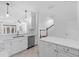 Bright, modern kitchen with white cabinets, stainless steel appliances and an adjacent staircase at 202 S Lincoln Ave, Tampa, FL 33609