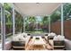 Screened patio featuring comfortable seating, tiled floors, and views of the lush backyard at 202 S Lincoln Ave, Tampa, FL 33609