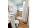 Updated bathroom featuring tile accents, white bath tub, and wood-look floors at 2172 University S Dr, Clearwater, FL 33764