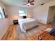 Bright bedroom with light walls, wood-look flooring, ceiling fan, and large rug under the bed at 2172 University S Dr, Clearwater, FL 33764