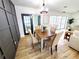 Inviting dining area featuring wood floors, modern wainscoting, stylish light fixture, and sliding door to pool at 2172 University S Dr, Clearwater, FL 33764