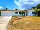 Charming one-story home with a manicured lawn, attached garage, and inviting front entrance at 2172 University S Dr, Clearwater, FL 33764