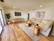 Bright living room with stylish seating, a decorative rug, hardwood floors, and a modern TV at 2172 University S Dr, Clearwater, FL 33764