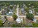 This aerial view displays a neighborhood with single Gathering homes, mature trees, and a street view at 2336 Windsor Oaks Ave, Lutz, FL 33549