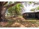 A spacious backyard boasts mature trees, a covered patio, and ample room for recreation at 2336 Windsor Oaks Ave, Lutz, FL 33549