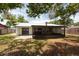 Back exterior view of a home with a covered patio and well-maintained yard, perfect for outdoor entertaining at 2336 Windsor Oaks Ave, Lutz, FL 33549