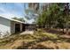 Exterior view of the rear of the house with a screen patio and spacious yard with mature trees at 2336 Windsor Oaks Ave, Lutz, FL 33549