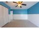 Comfortable bedroom features a ceiling fan, tile flooring, and half wall wainscoting at 2336 Windsor Oaks Ave, Lutz, FL 33549