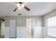 Spacious bedroom with wainscoting, ceiling fan, neutral paint, and access to an en-suite bathroom at 2336 Windsor Oaks Ave, Lutz, FL 33549