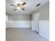 Bedroom with neutral walls, tile flooring, ceiling fan, and wainscoting, with a door leading outside at 2336 Windsor Oaks Ave, Lutz, FL 33549