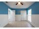 Comfortable bedroom features a ceiling fan, tile flooring, and half wall wainscoting at 2336 Windsor Oaks Ave, Lutz, FL 33549