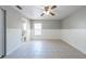 Bedroom featuring neutral paint, wainscoting, tile floors, ceiling fan, and access to an en-suite bathroom at 2336 Windsor Oaks Ave, Lutz, FL 33549