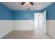 Comfortable bedroom features a ceiling fan, tile flooring, and half wall wainscoting at 2336 Windsor Oaks Ave, Lutz, FL 33549