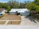 Charming single-story home featuring a metal roof, attached garage, and concrete driveway on a sunny day at 2336 Windsor Oaks Ave, Lutz, FL 33549