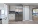 Kitchen view of stainless refrigerator, modern backsplash and flooring, white cabinets, and access to the screened patio at 2336 Windsor Oaks Ave, Lutz, FL 33549