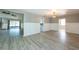 Spacious living room with wainscoting, modern flooring and lighting, and access to other rooms and screened patio at 2336 Windsor Oaks Ave, Lutz, FL 33549