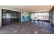 A covered patio with a brick floor features a sliding glass door entrance and outdoor seating at 2336 Windsor Oaks Ave, Lutz, FL 33549