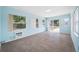 Living room with tiled floors, bright blue walls, and multiple windows showing outside greenery and a sliding glass door at 2350 38Th N Ave, St Petersburg, FL 33713