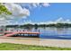 Waterfront property featuring a private dock on a serene lake under a blue sky with scattered clouds at 2424 W Tampa Bay Blvd # I202, Tampa, FL 33607
