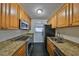 Galley kitchen features granite countertops, stainless steel appliances, and wood cabinets at 2424 W Tampa Bay Blvd # I202, Tampa, FL 33607
