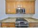 Kitchen with stainless steel appliances, granite countertops, and wood cabinets at 2424 W Tampa Bay Blvd # I202, Tampa, FL 33607