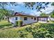 Home exterior showcases a lush, green lawn and enclosed lanai with tree shade at 2967 Macalpin N Dr, Palm Harbor, FL 34684