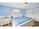 Bedroom featuring a blue accent wall, plank flooring and white trim throughout at 2967 Macalpin N Dr, Palm Harbor, FL 34684