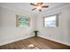 This bedroom has two windows, hard wood flooring, and white trim at 2967 Macalpin N Dr, Palm Harbor, FL 34684