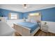 Bright bedroom features blue walls, white wainscoting, hardwood floors, and comfortable furniture at 2967 Macalpin N Dr, Palm Harbor, FL 34684