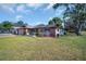 Beautiful single-story home with a manicured lawn and inviting front patio seating area at 2967 Macalpin N Dr, Palm Harbor, FL 34684