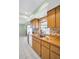 Traditional kitchen features wood cabinets, wood countertop and stainless steel sink under a window with floral wallpaper border at 2967 Macalpin N Dr, Palm Harbor, FL 34684
