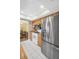 Kitchen featuring stainless steel refrigerator, wood cabinets, and white tile flooring at 2967 Macalpin N Dr, Palm Harbor, FL 34684