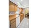 Kitchen featuring natural wood cabinetry, white appliances, and tile flooring at 2967 Macalpin N Dr, Palm Harbor, FL 34684