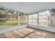 Sunroom features tile flooring, white window frames, bright lighting and views of the backyard at 2967 Macalpin N Dr, Palm Harbor, FL 34684