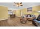 Cozy living room featuring hardwood floors, a ceiling fan, and ample seating at 2967 Macalpin N Dr, Palm Harbor, FL 34684