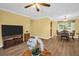Open-concept living area featuring wood floors, a TV, and a dining table at 2967 Macalpin N Dr, Palm Harbor, FL 34684