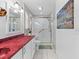 Well-lit bathroom featuring a red countertop and glass-enclosed shower at 3025 50Th St S S St, Gulfport, FL 33707