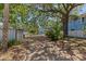 Long driveway leading to a garage, surrounded by mature trees and landscaping, offering ample parking space at 3025 50Th St S S St, Gulfport, FL 33707