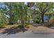 Spacious driveway leading to a garage, set amongst mature trees and landscaping at 3025 50Th St S S St, Gulfport, FL 33707