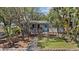 Well-maintained single-story home with a blue-trimmed door, complemented by lush tropical landscaping and mature trees at 3025 50Th St S S St, Gulfport, FL 33707