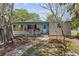 Charming single-story home featuring a blue door and trim, complemented by lovely landscaping and a stone walkway at 3025 50Th St S S St, Gulfport, FL 33707