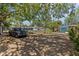 Landscaped front yard featuring a gravel driveway, mature trees and well maintained landscaping, offering curb appeal at 3025 50Th St S S St, Gulfport, FL 33707