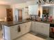 Inviting kitchen with white cabinets, a large granite counter, and stainless steel sink at 31258 Park Ridge Dr, Brooksville, FL 34602