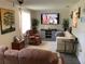 Cozy living room with comfortable seating, mounted TV, modern decor, and large windows with natural light at 31258 Park Ridge Dr, Brooksville, FL 34602
