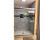 Updated shower featuring glass doors, tiled walls, built-in shelf and overhead lighting at 31258 Park Ridge Dr, Brooksville, FL 34602