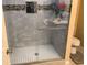 Updated shower featuring glass doors, tiled walls and flooring, built-in shelves, and overhead lighting at 31258 Park Ridge Dr, Brooksville, FL 34602