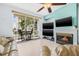 Bright living room featuring a fireplace, ceiling fan, tiled floors, and sliding doors leading to a furnished balcony at 320 Island Way # 202, Clearwater Beach, FL 33767