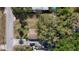 Aerial shot of home showcasing a yard with mature trees, a detached garage, and driveway with ample parking at 38327 Palm Grove Dr, Zephyrhills, FL 33542