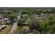 Aerial view capturing the street, trees, and house with a verdant green space nestled in a tranquil neighborhood at 38327 Palm Grove Dr, Zephyrhills, FL 33542